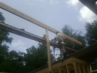 Carpenter setting a ridge beam over a new addition frame — Ice Dam Removal by Roofing Brothers in Naugatuck