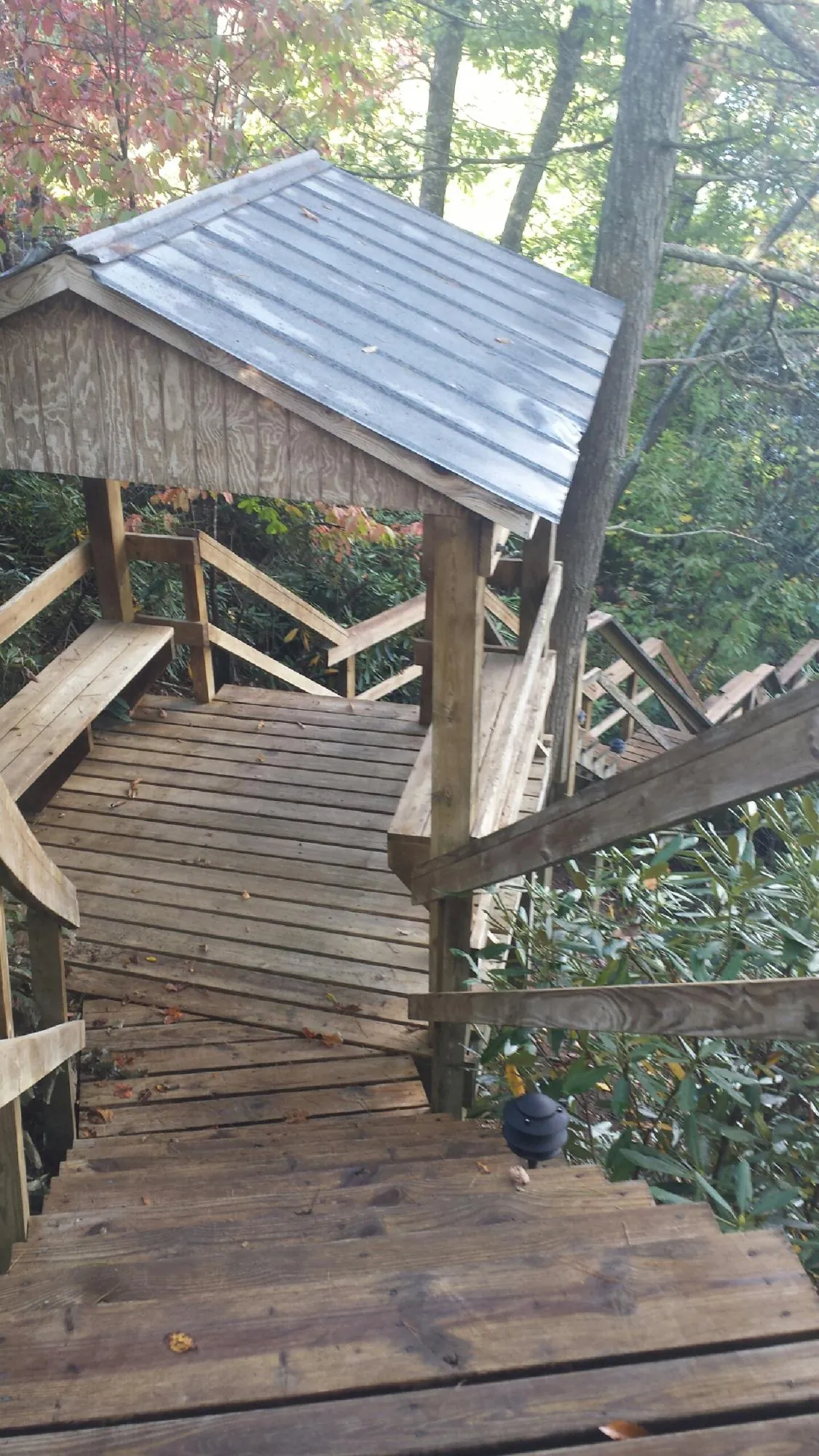 Metal roofed shelter over wooden steps on a wooded walkway — Skylight Repair & Installation work by our crew in Naugatuck